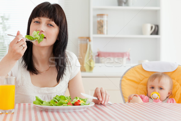 Atractiv bruneta femeie mananca salată copil Imagine de stoc © wavebreak_media