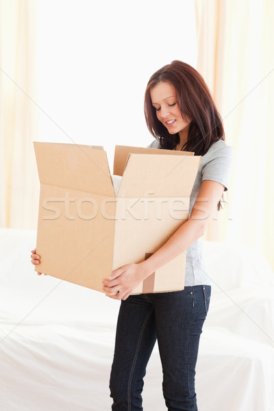 A standing woman is looking into a cardboard Stock photo © wavebreak_media