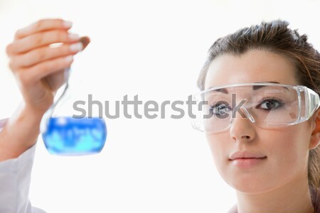 Close up of a cute scientist looking at a flask with the camera focus on the model Stock photo © wavebreak_media