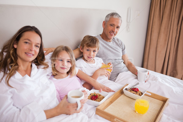 Souriant famille déjeuner chambre regarder caméra [[stock_photo]] © wavebreak_media