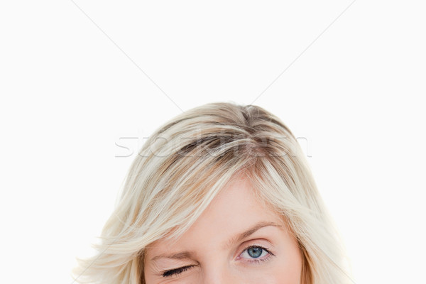 Upper part of the face of a woman blinking an eye againt a white background Stock photo © wavebreak_media