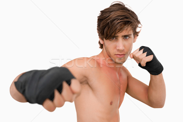 Martial arts fighter attacking with his fist against a white background Stock photo © wavebreak_media