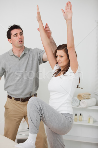 Stock photo: Woman standing while doing her exercises in a room