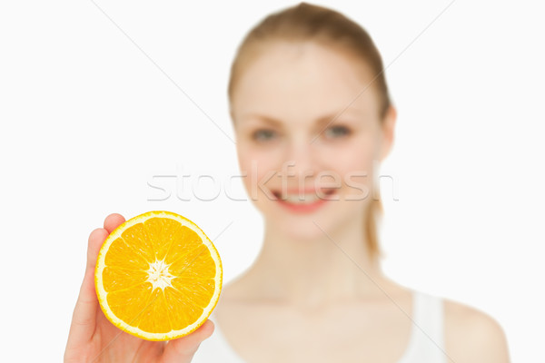 Smiling woman holding an orange against white background Stock photo © wavebreak_media