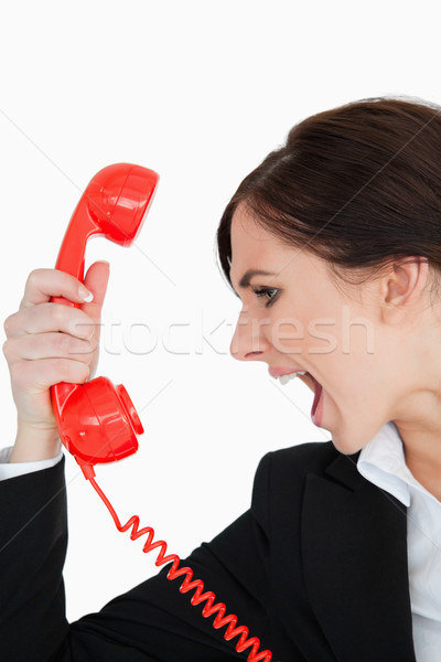 Woman in suit screaming on a red dial telephone against white background Stock photo © wavebreak_media
