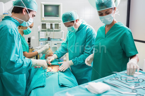 Nurse holding surgical tool next to operating table in an operating theatre Stock photo © wavebreak_media