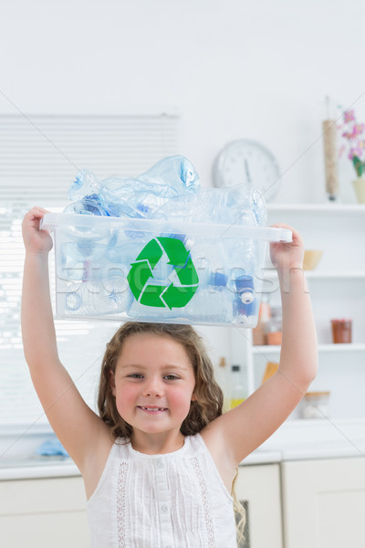 Smiling girl holding crate with plastics on her head Stock photo © wavebreak_media