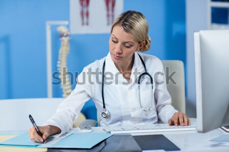 Stock photo: Doctor using computer to prepare an online prescription