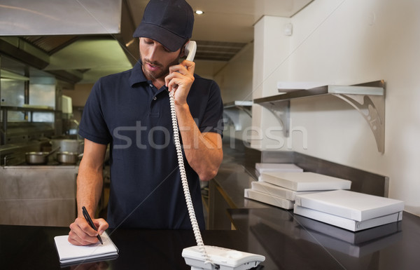 Handsome pizza delivery man taking an order over the phone Stock photo © wavebreak_media