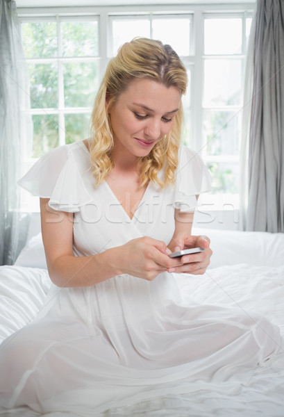 Csinos szőke nő ül ágy küldés szöveges üzenet Stock fotó © wavebreak_media