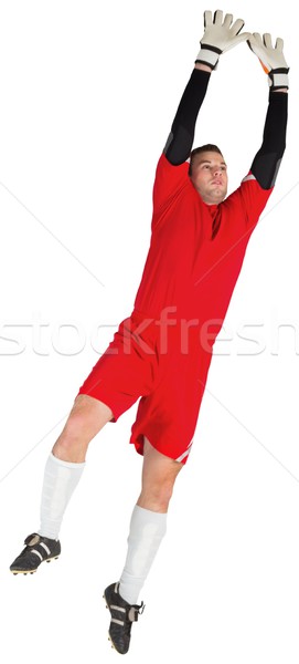 Gardien de but rouge sautant up blanche football [[stock_photo]] © wavebreak_media