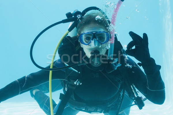 Stock photo: Woman on scuba training submerged in swimming pool making ok sig