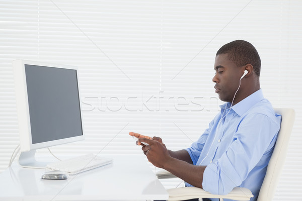 Businessman listening to music while he works Stock photo © wavebreak_media