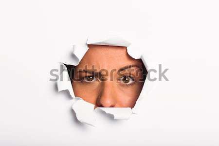 Young woman looking through paper rip Stock photo © wavebreak_media