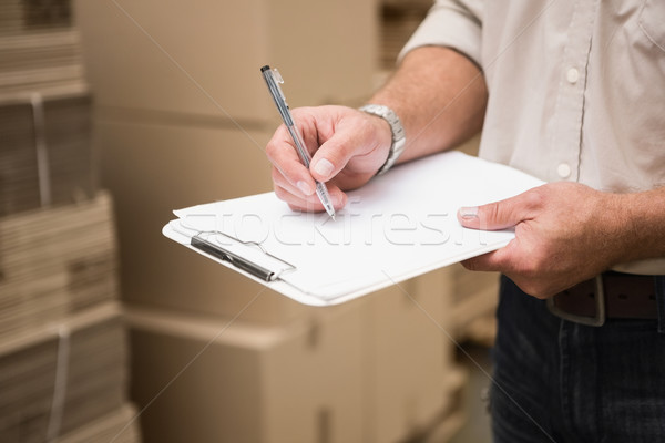 Stock photo: Warehouse worker checking his list on clipboard