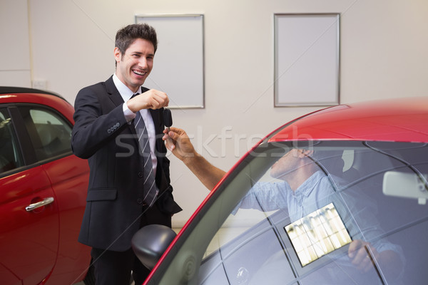 Businessman giving car key while shaking a customer hand Stock photo © wavebreak_media