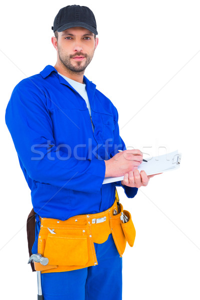 Handyman in blue overall writing on clipboard Stock photo © wavebreak_media