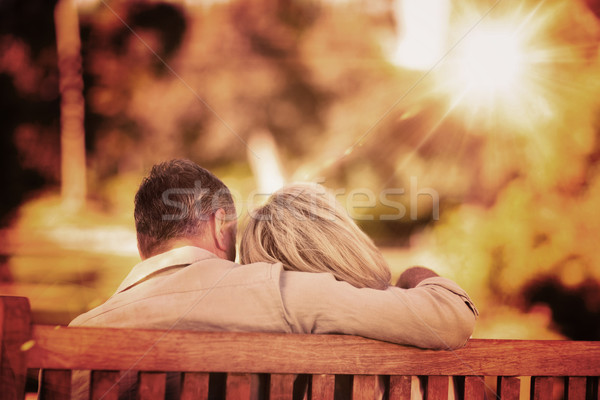 Stock photo: Composite image of elderly couple sitting on the bench with thei