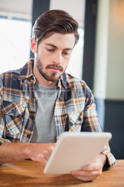 Handsome young man using digital tablet Stock photo © wavebreak_media