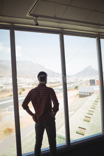 Businessman looking through glass window in office Stock photo © wavebreak_media