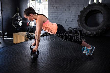 Rear view of shirtless man lifting heavy kettlebell Stock photo © wavebreak_media