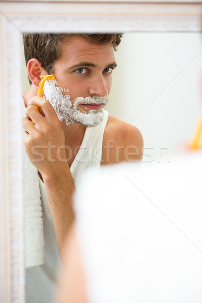 Reflection of young man shaving Stock photo © wavebreak_media