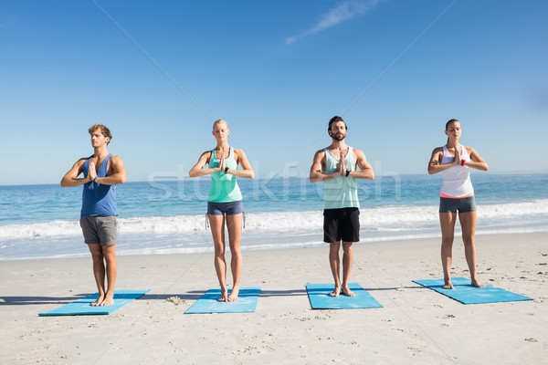 People doing yoga on the beach Stock photo © wavebreak_media