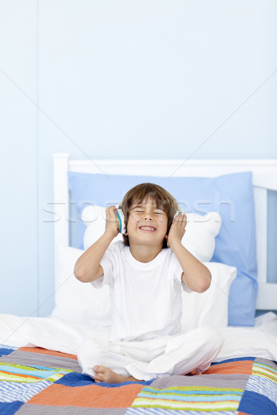 小 男孩 聽音樂 頭戴耳機 床 快樂 商業照片 © wavebreak_media