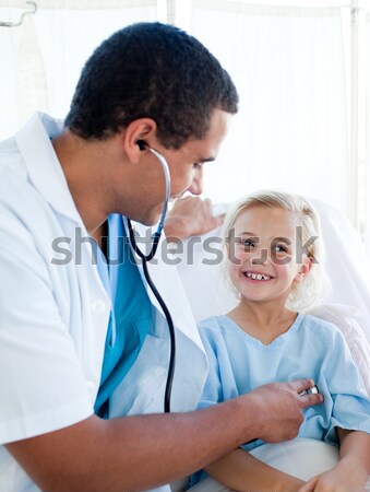 Male doctor checking the pulse on a smiling little patient Stock photo © wavebreak_media