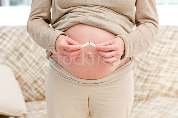 Femeie gravida ţigară în picioare camera de zi zâmbet Imagine de stoc © wavebreak_media