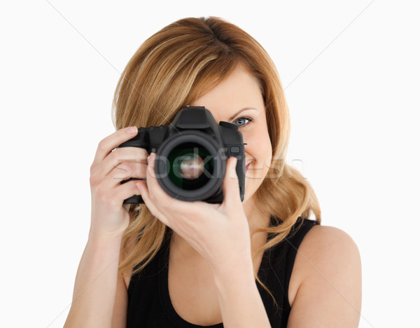 Blond-haired woman taking a photo with a camera on a white background Stock photo © wavebreak_media