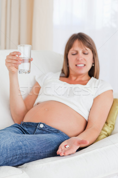 Femeie gravida pilulă canapea apartament mână Imagine de stoc © wavebreak_media