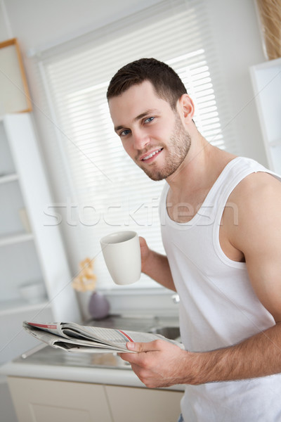 Delighted man drinking coffee while reading the news in his kitchen Stock photo © wavebreak_media