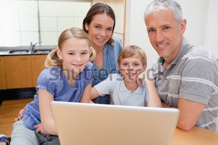 Stock photo: Lovely family using a laptop in their kitchen