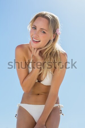 Stock photo: Young attractive woman measuring her waist against a white background