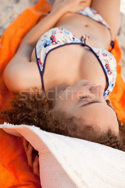 Jovem mulher toalha de praia banhos de sol praia Foto stock © wavebreak_media