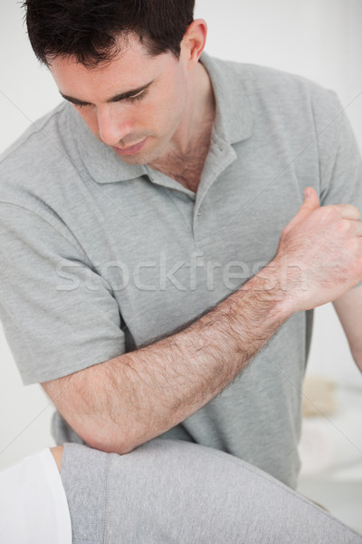 Stock photo: Physiotherapist using his elbow on the hip of a woman in a room