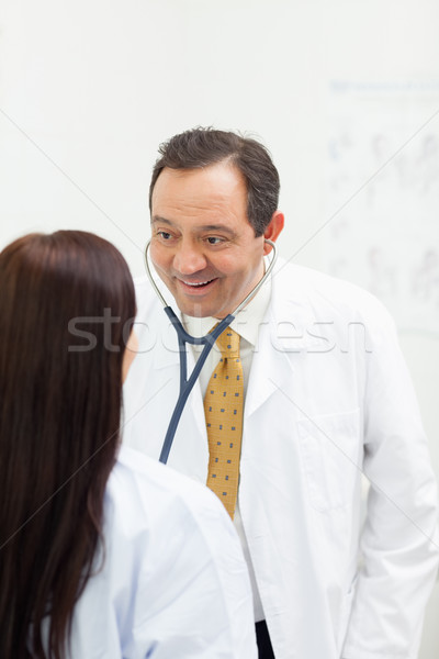 Smiling woman auscultating a woman while smiling in an examination room Stock photo © wavebreak_media