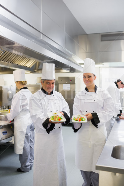 Foto stock: Dois · sorridente · chefs · salmão · pratos