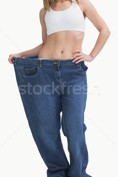 Młoda kobieta starych spodnie utraty wagi biały Zdjęcia stock © wavebreak_media