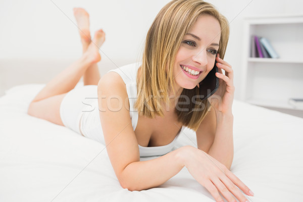 Casual woman using mobile phone in bed Stock photo © wavebreak_media