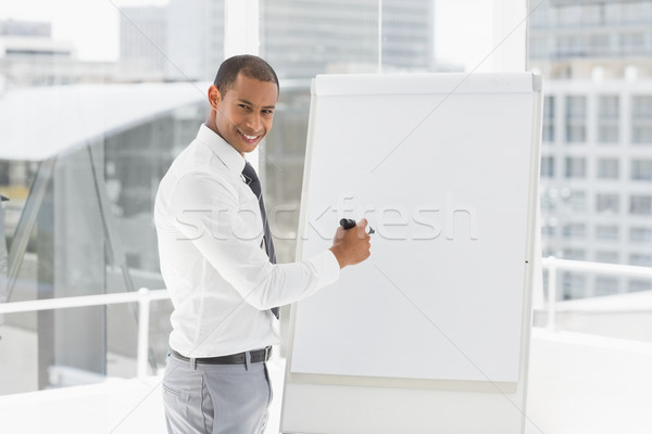 Young happy businessman presenting at whiteboard with marker Stock photo © wavebreak_media