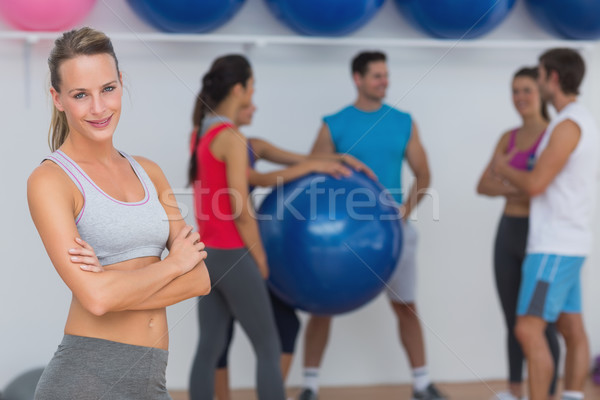 Fit Young Woman With Friends In Background At Fitness Studio Stock Photo C Wavebreak Media Stockfresh