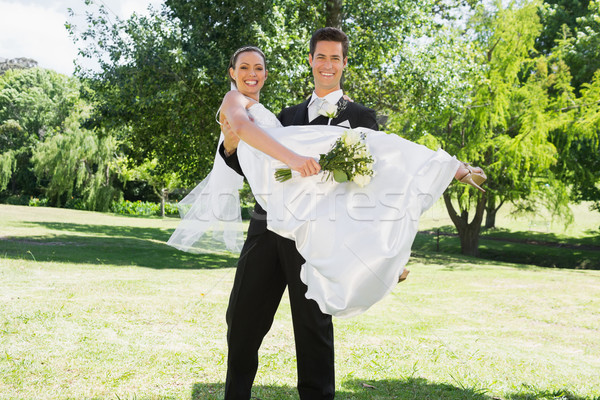 Young groom lifting bride in arms at garden Stock photo © wavebreak_media