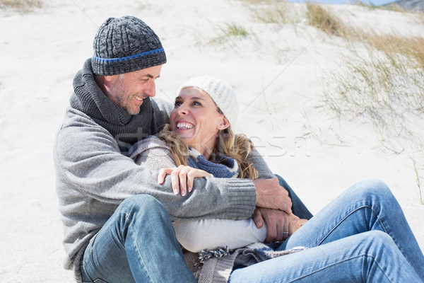 Attractive couple smiling at each other on the beach in warm clo Stock photo © wavebreak_media