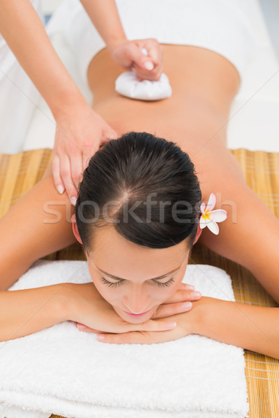 Peaceful brunette enjoying a herbal compress massage Stock photo © wavebreak_media
