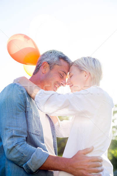 Cute couple holding balloons at the park  Stock photo © wavebreak_media