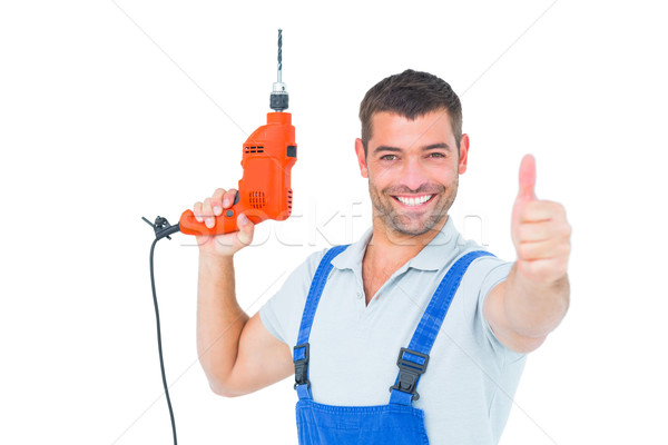 Smiling repairman with drill machine gesturing thumbs up Stock photo © wavebreak_media