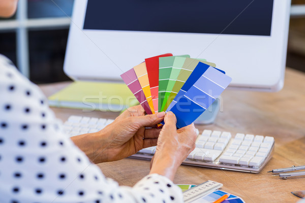Stock photo: Casual businesswoman looking at colour swatch