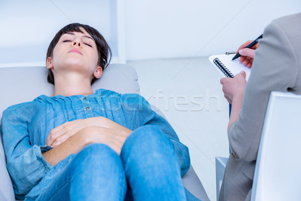 Stock photo: Pensive woman lying on the couch while psychologist writing